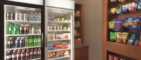 Máquina de vendas abastecida com lanches e bebidas, incluindo refrigerantes e energéticos.