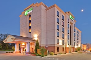 A Holiday Inn Express hotel with a modern design, featuring a prominent entrance and a parking lot.