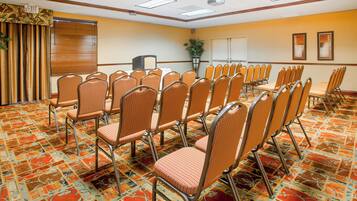 A conference room with rows of chairs, a projector, and a whiteboard.