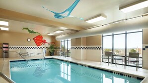 An indoor swimming pool with clear water, a lifeguard chair, and a view of the outside through large windows. - Hampton Inn & Suites Ephrata - Mountain Springs (Ephrata)