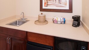 A kitchen with a sink, a coffee maker, a microwave, and a framed picture on the wall. - Hampton Inn & Suites Schertz (Schertz)