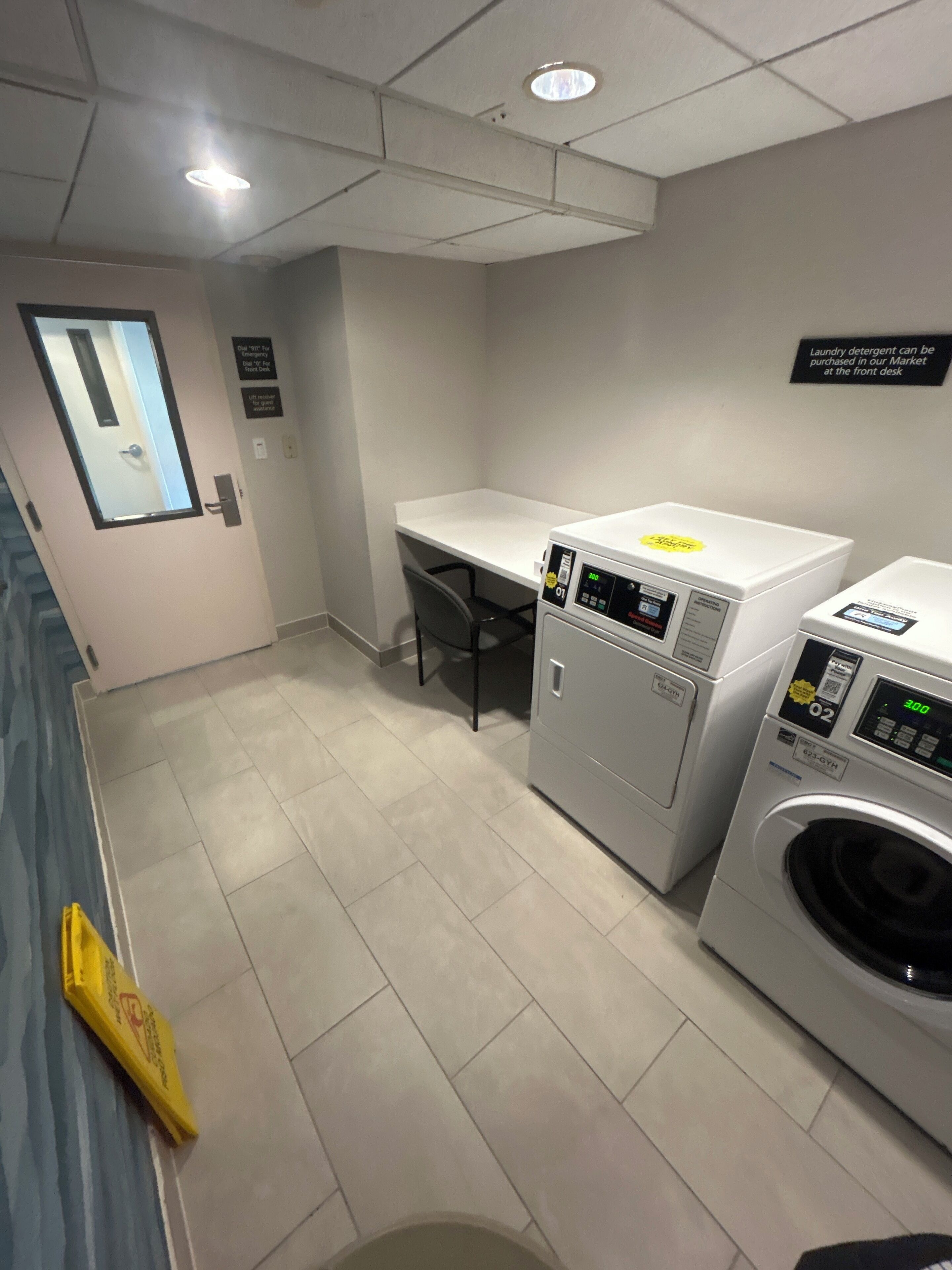 A laundry room with two washing machines, a sink, and a mirror.