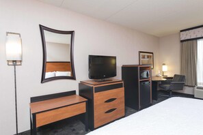 A hotel room with a bed, a TV, a desk, a mirror, a microwave, and a chair. - Hampton Inn and Suites Indianapolis - Fishers (Fishers)