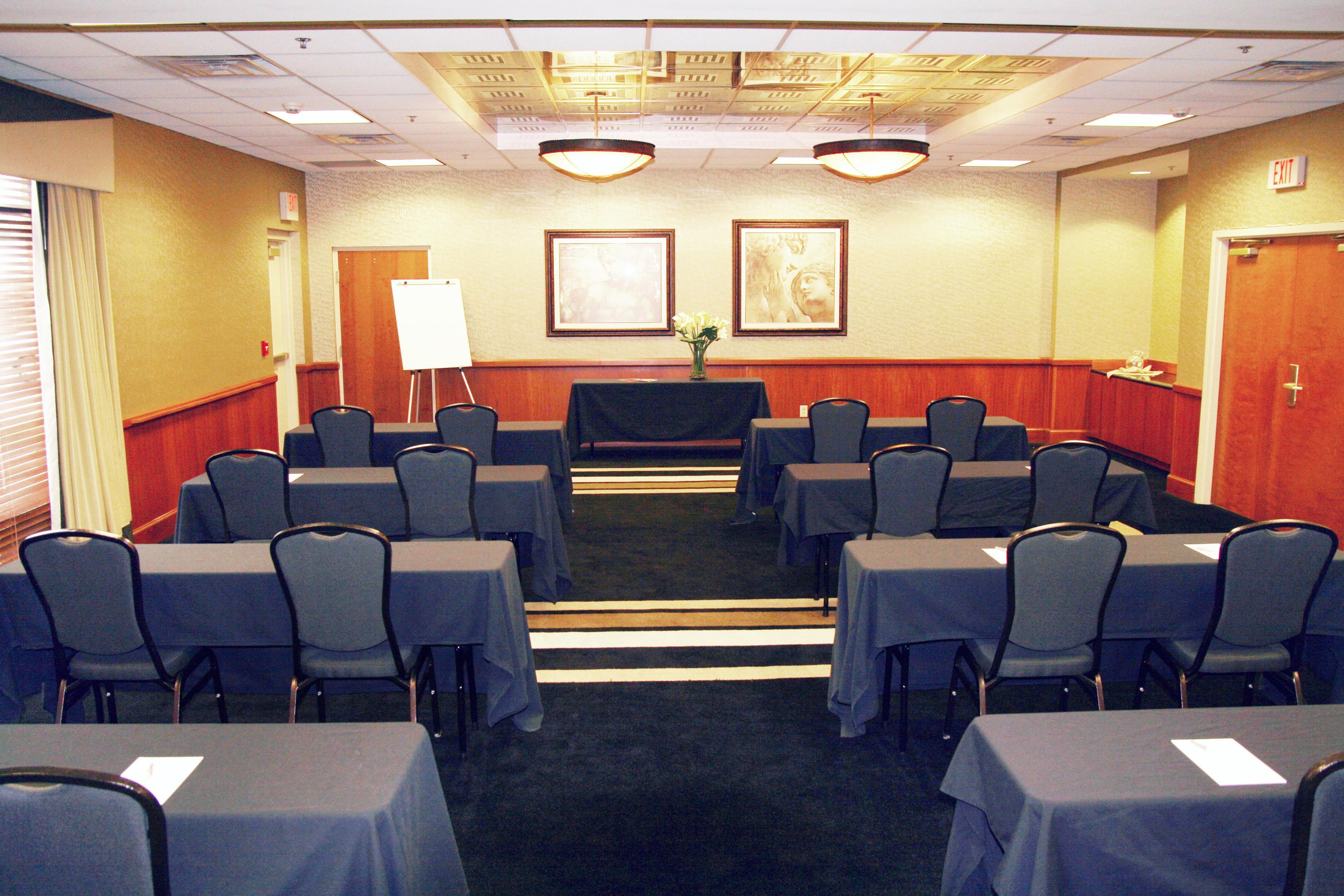 Una sala de conferencias con mesas y sillas dispuestas para reuniones.