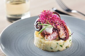 Un piatto con polpo e purè di patate.