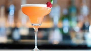 Un cóctel en una copa de martini, adornado con una fresa.