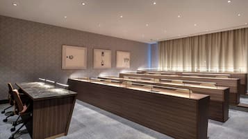 A modern conference room with a long table, multiple chairs, and a carpeted floor.
