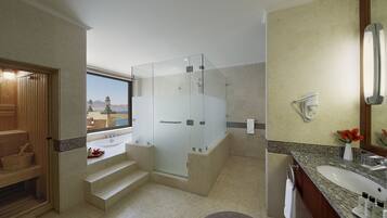 Un bany modern amb dutxa amb envàs de vidre, un gran lavabo i vista a un paisatge de muntanya.