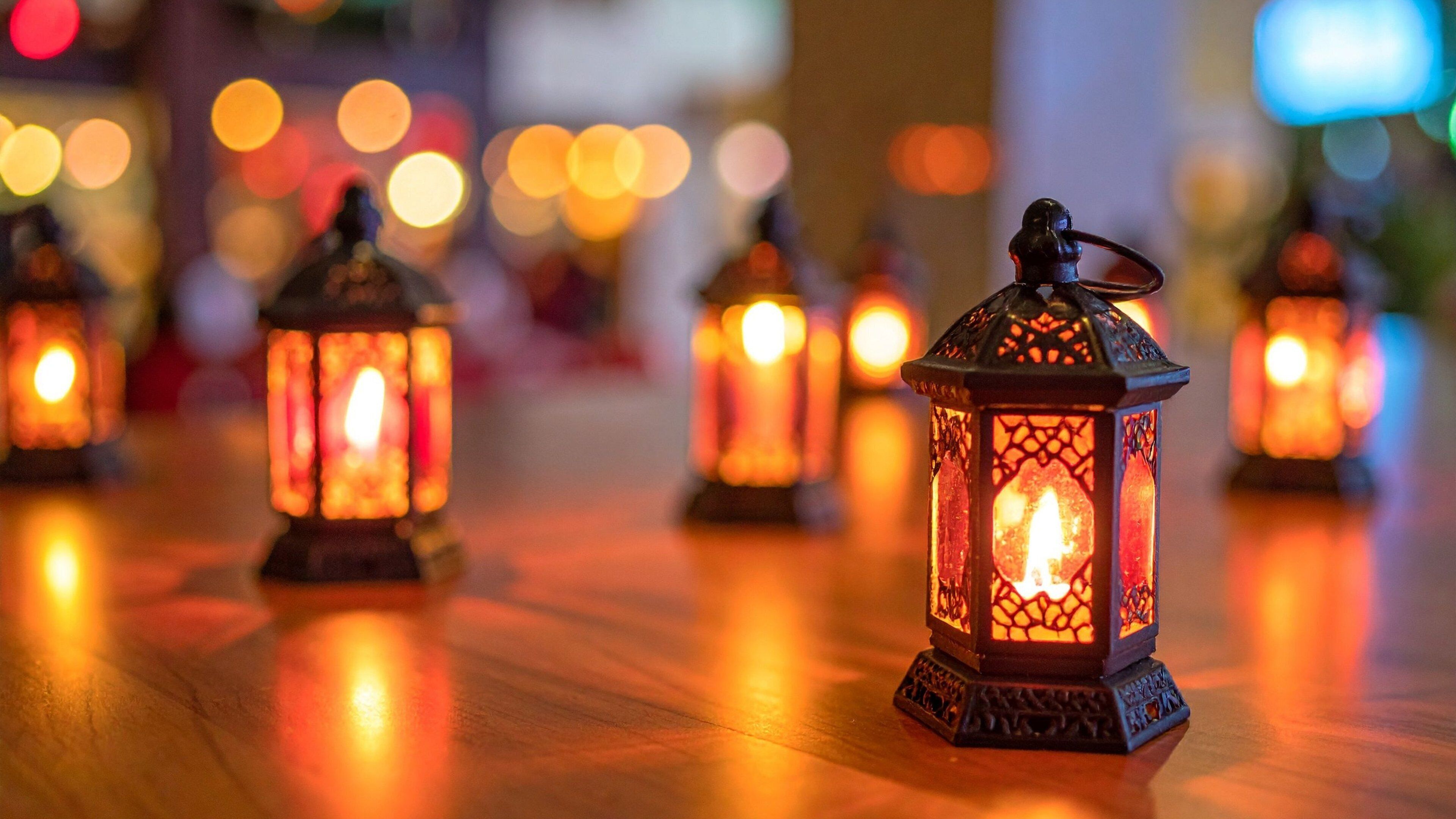 A row of lit lanterns on a wooden floor.