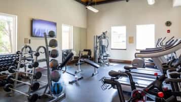 A gym with various exercise equipment, including treadmills, weight machines, and free weights.