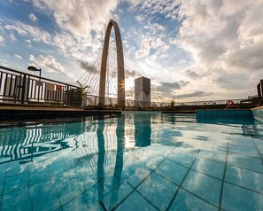 A swimming pool with a view of a large bridge and buildings in the background. - Mercure São José Dos Campos Hotel (São José dos Campos)