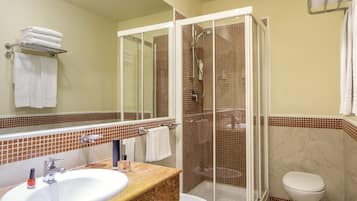 Un baño moderno con ducha de vidrio, lavamanos con encimera de mármol y retrete.