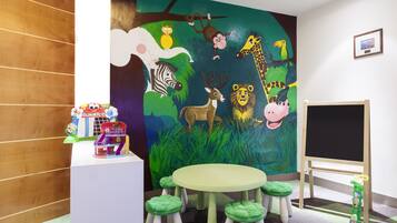 Children can play and learn in this colorful playroom featuring a whimsical mural and a playhouse.