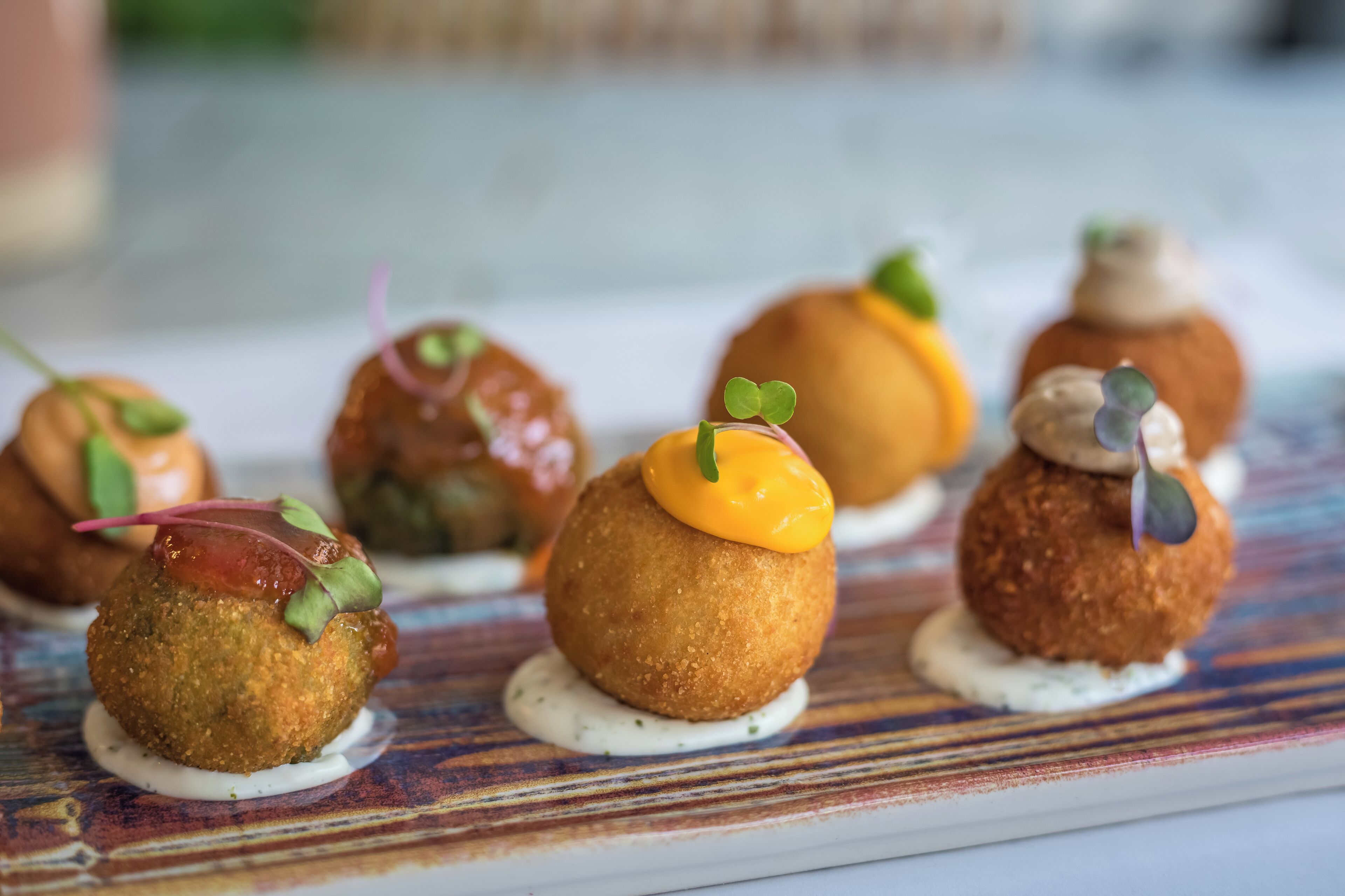 A plate of assorted appetizers with a variety of garnishes and sauces.