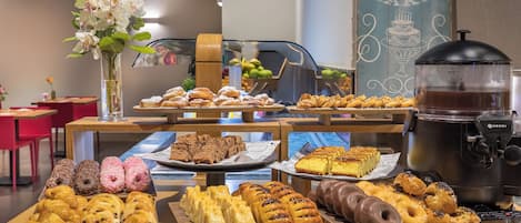 Un buffet de petit-déjeuner proposant diverses pâtisseries et une machine à café.