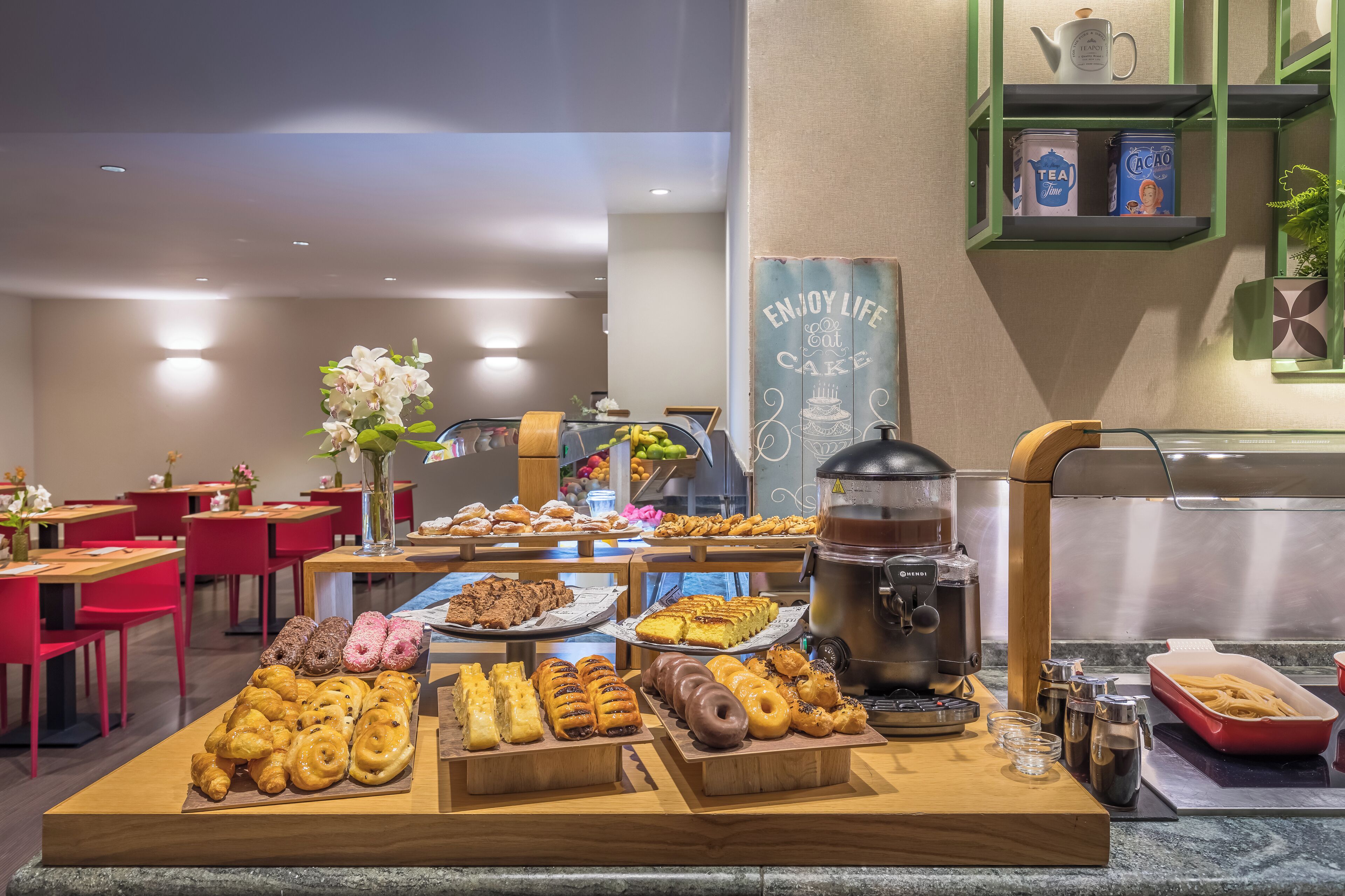 Zona de bufé con diversos pasteles y una estación de café.