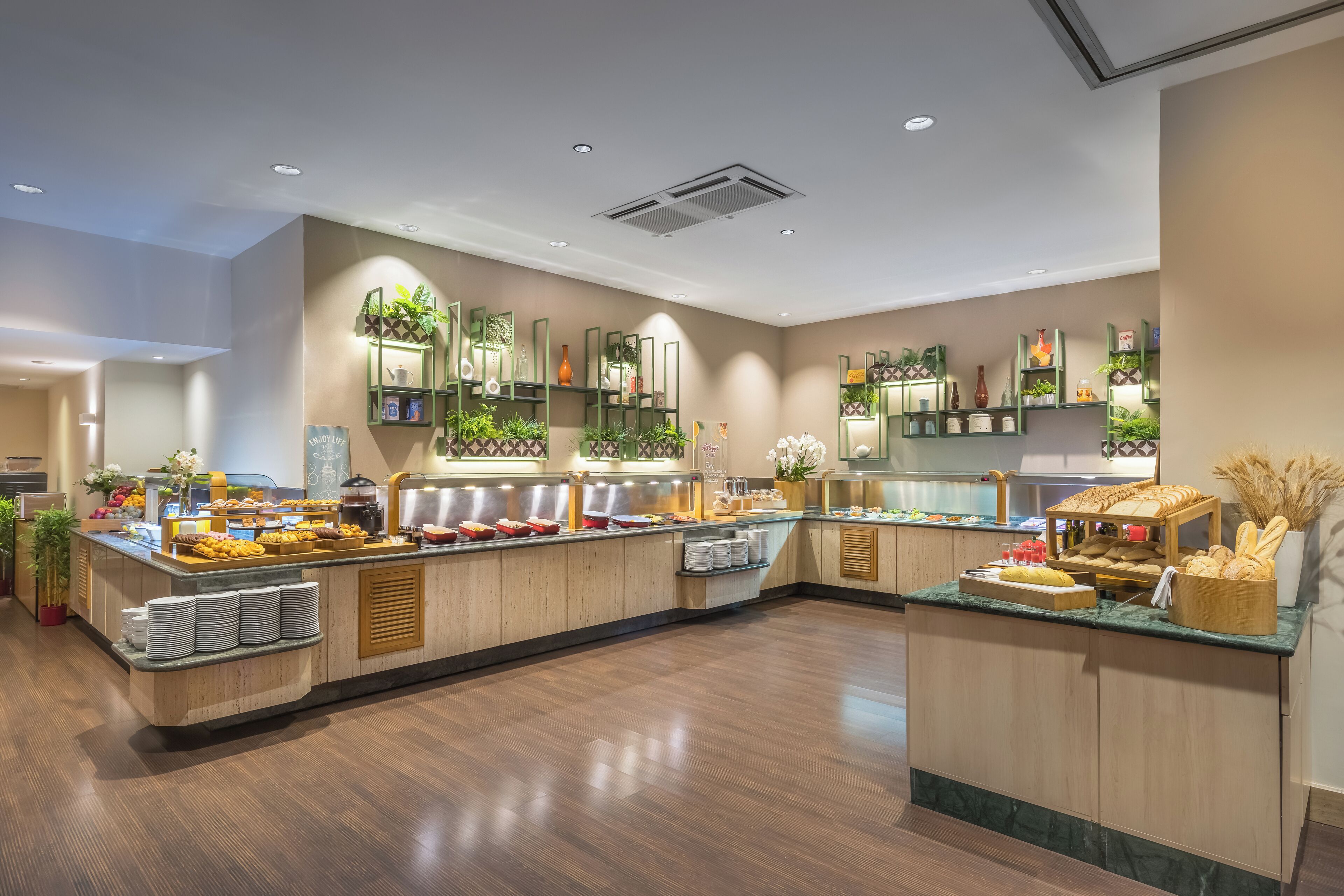 A buffet area with various food items and decorative plants.