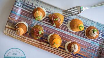 Un plato de aperitivos con un tenedor sobre una mesa estampada.