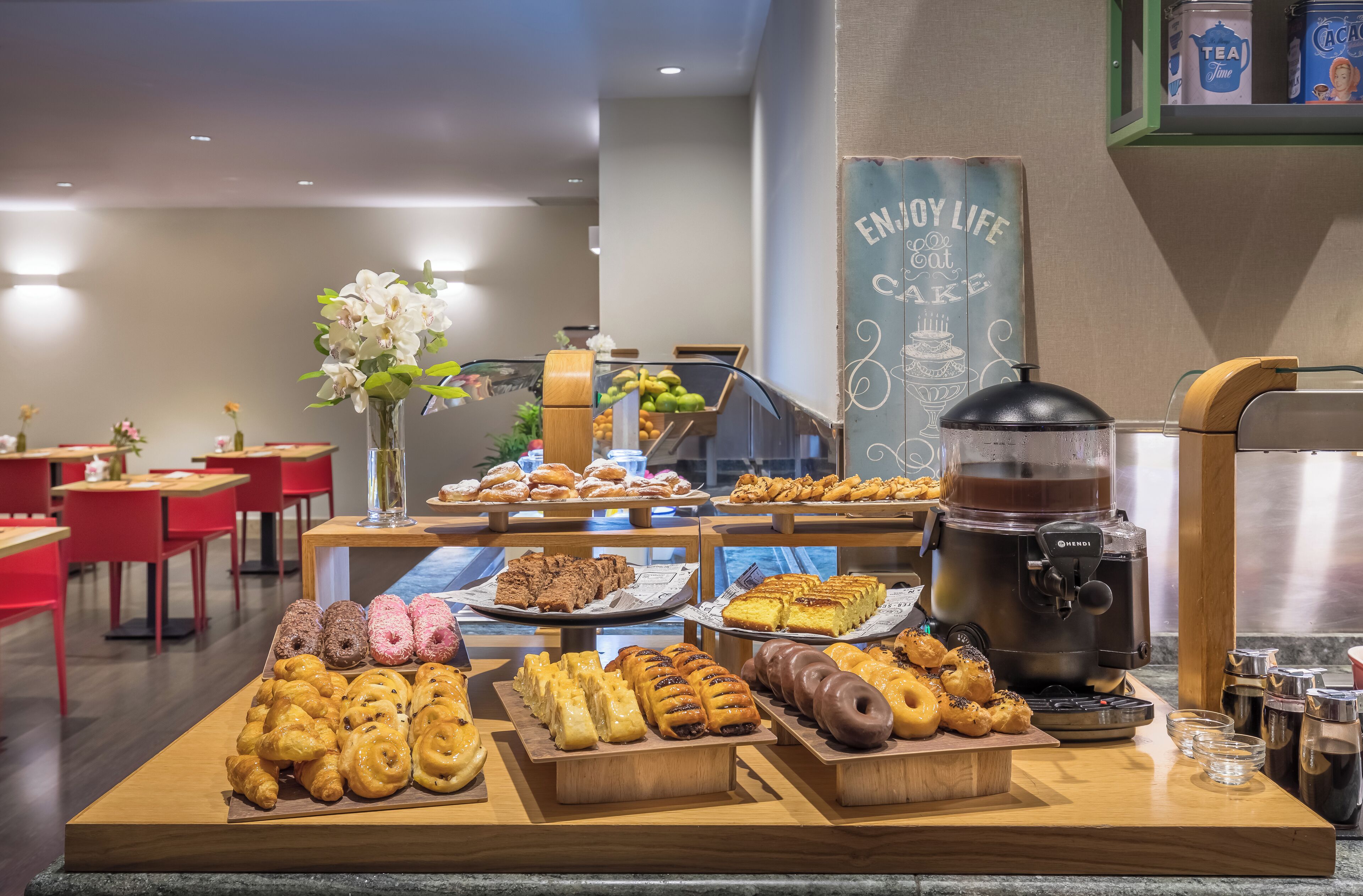 A buffet with various pastries and a coffee machine.