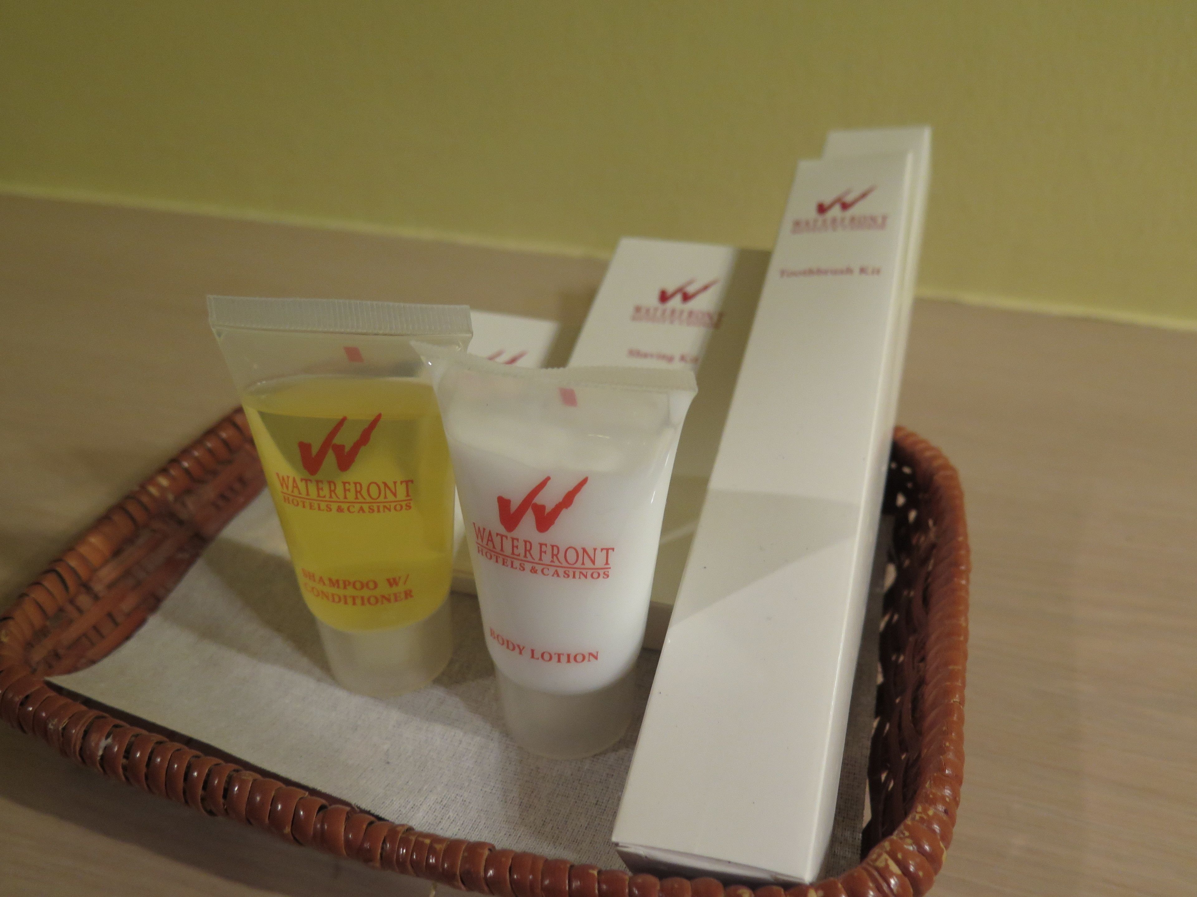A tray with toiletries including a shampoo bottle, body lotion, and a box.
