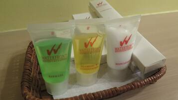A tray with three toiletry items from Waterfront Hotels & Casinos: bath gel, shampoo conditioner, and body lotion.