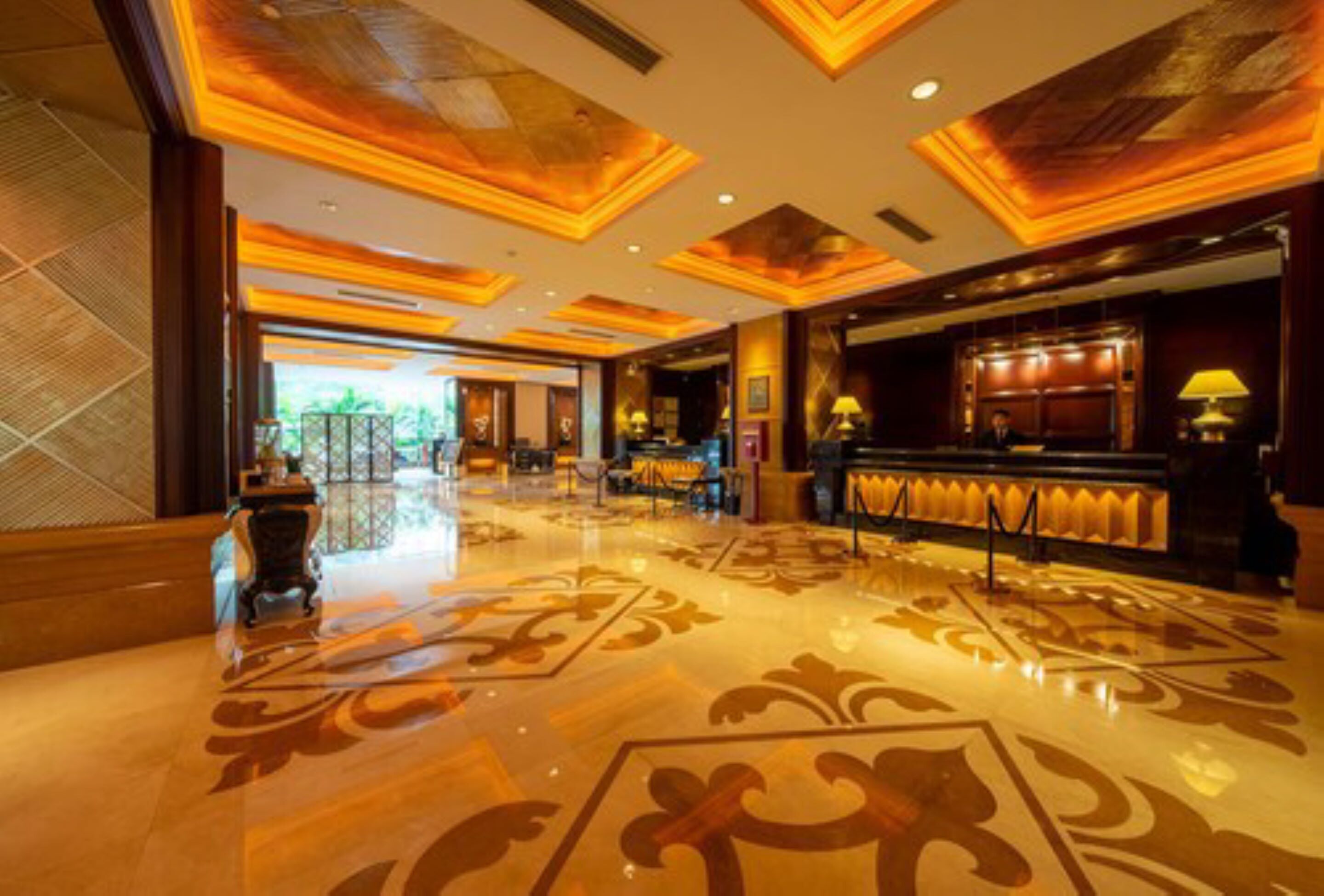 A spacious lobby with a polished floor and ornate ceiling design.