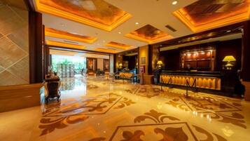 A spacious lobby with a polished floor and ornate ceiling design.