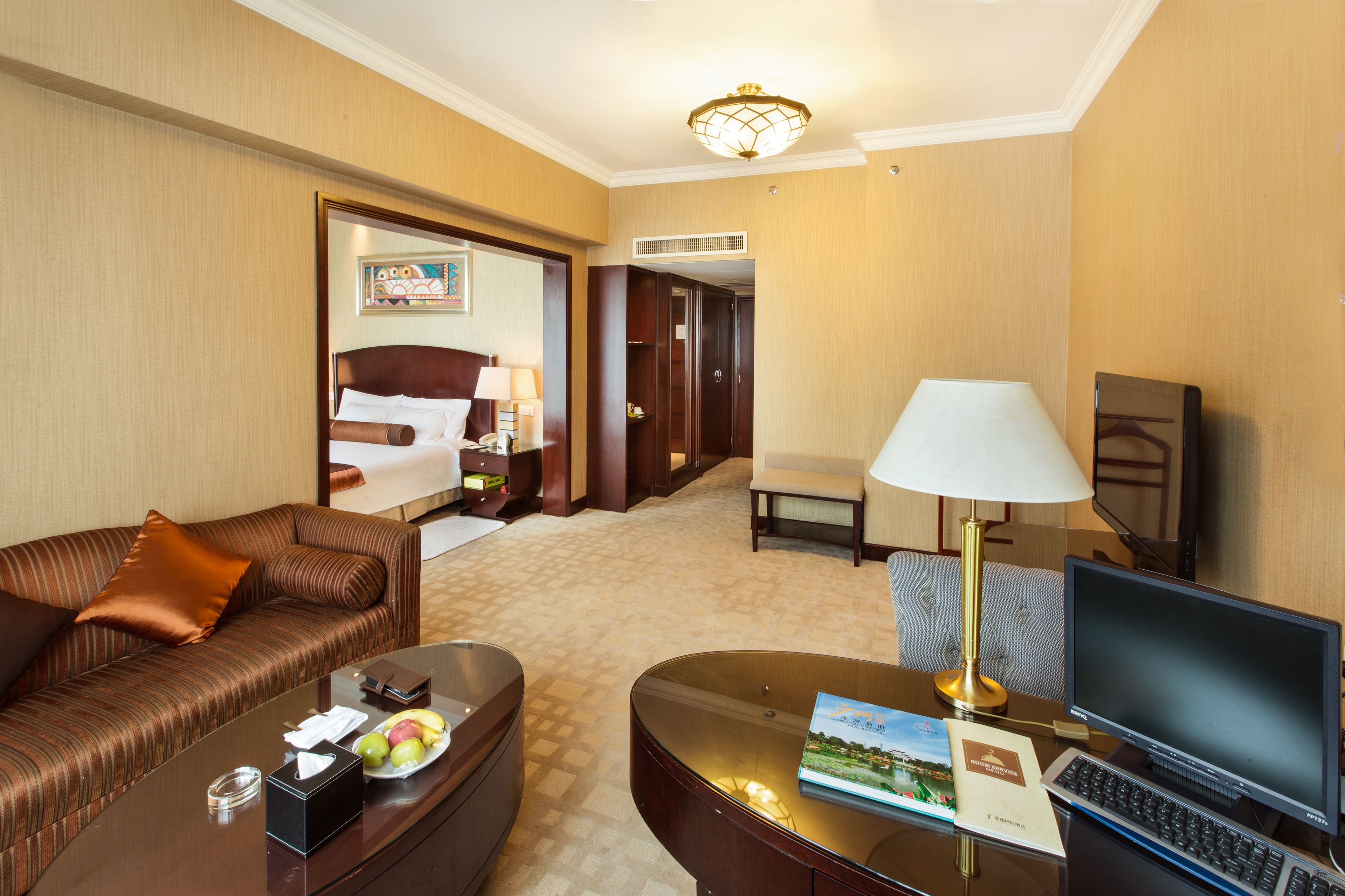 Une chambre d’hôtel avec un lit, un bureau, une chaise, une télévision et une lampe.