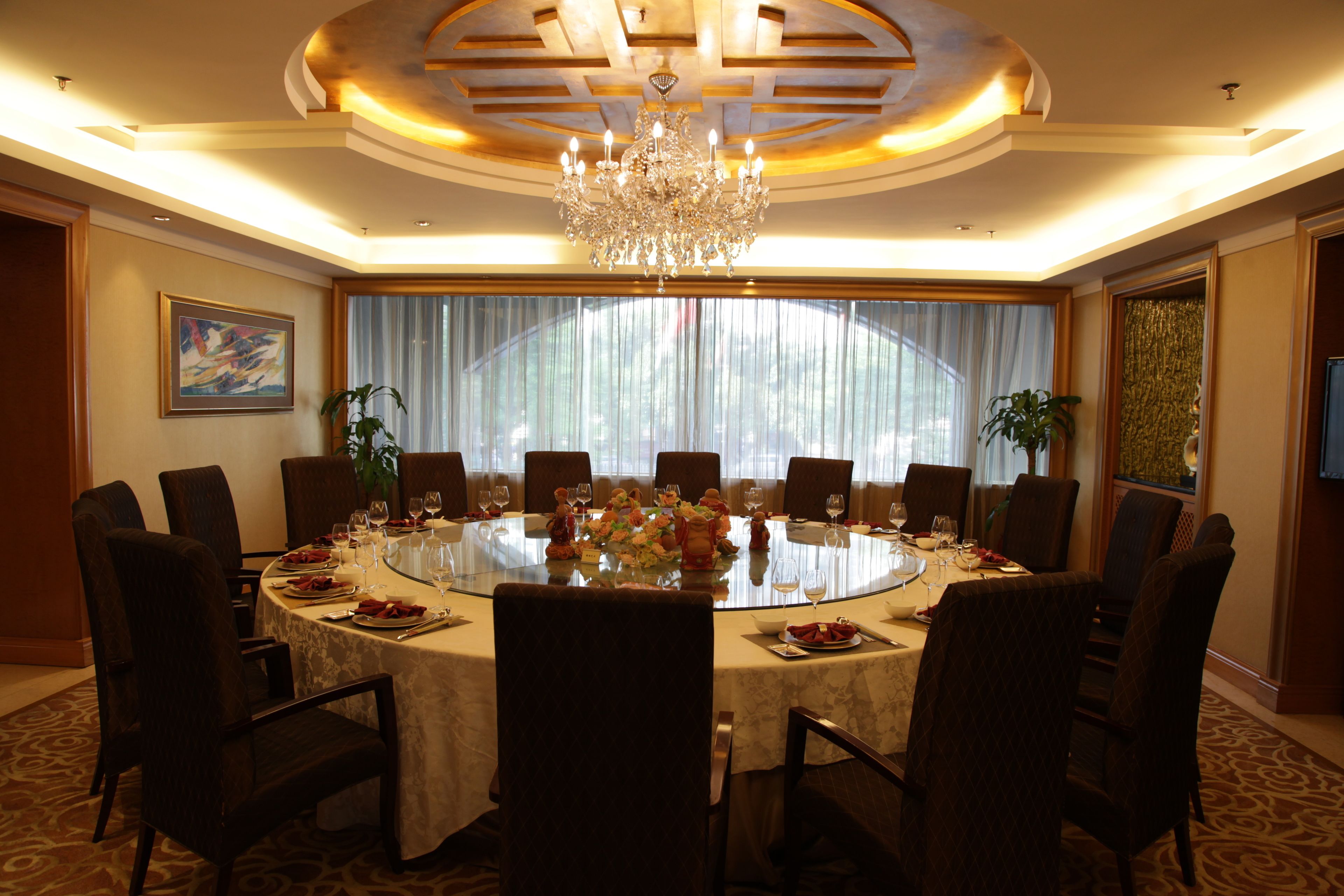 Una sala da pranzo elegante con un tavolo rotondo, sedie e un lampadario.