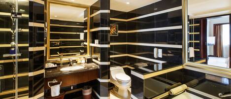Un baño moderno con un espejo grande, un lavabo, un inodoro y una bañera.