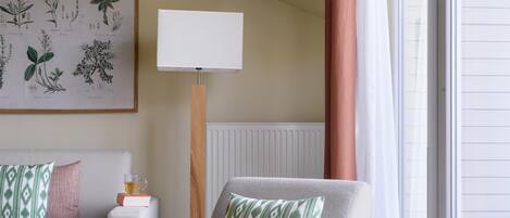 Una sala de estar moderna con un sofá, un sillón y una lámpara de pie.