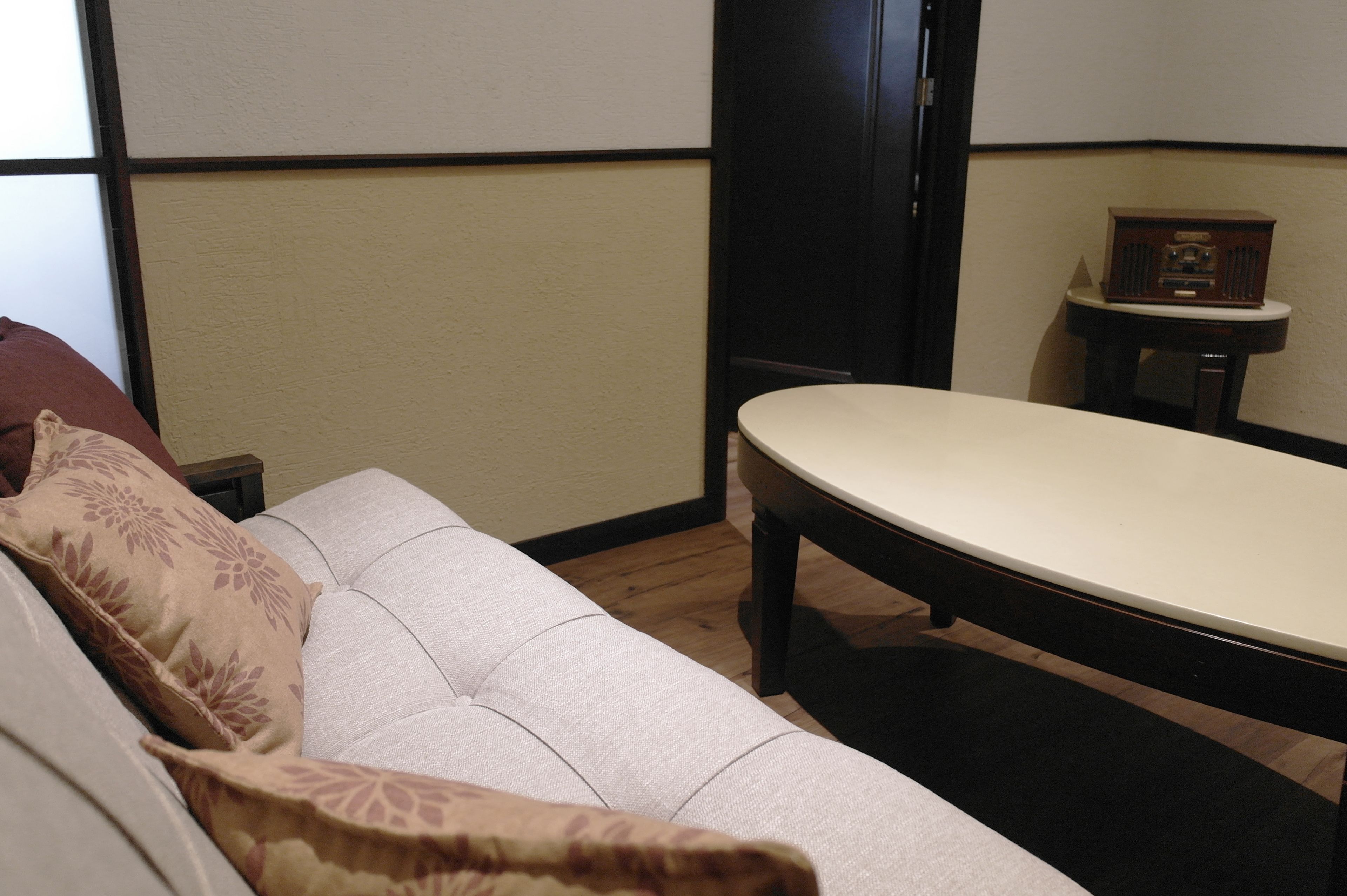 A room with a sofa, a small table, and a radio.