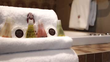 Un baño con una toalla blanca y varias botellas de loción en un estante.