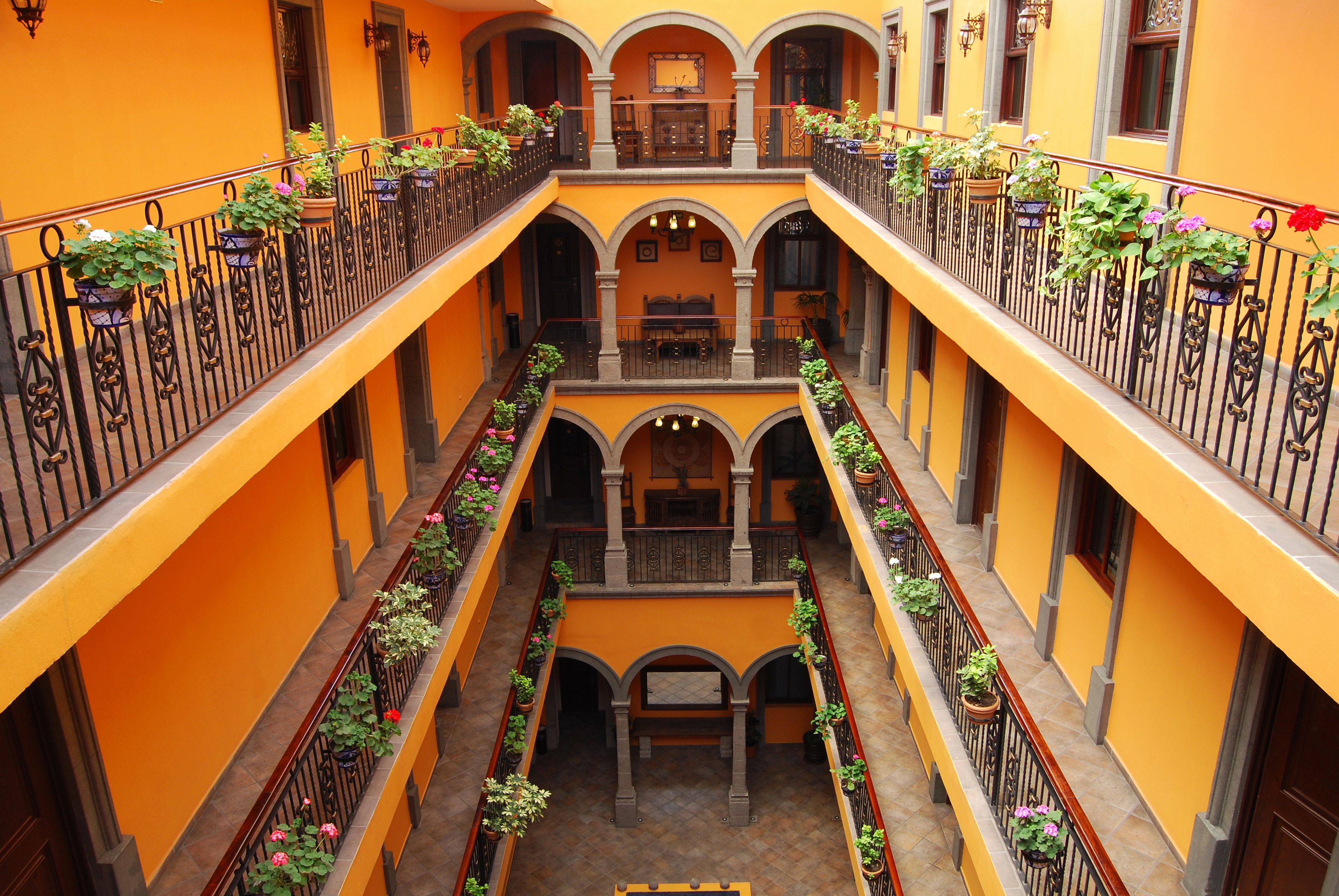 Un patio de varios niveles con balcones, cada uno decorado con macetas y flores.