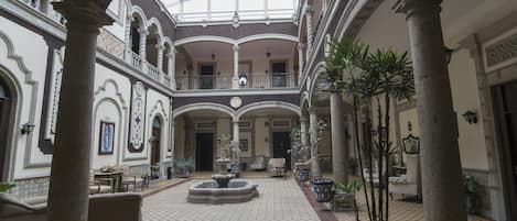 A spacious atrium with a high ceiling, ornate columns, and a central fountain.