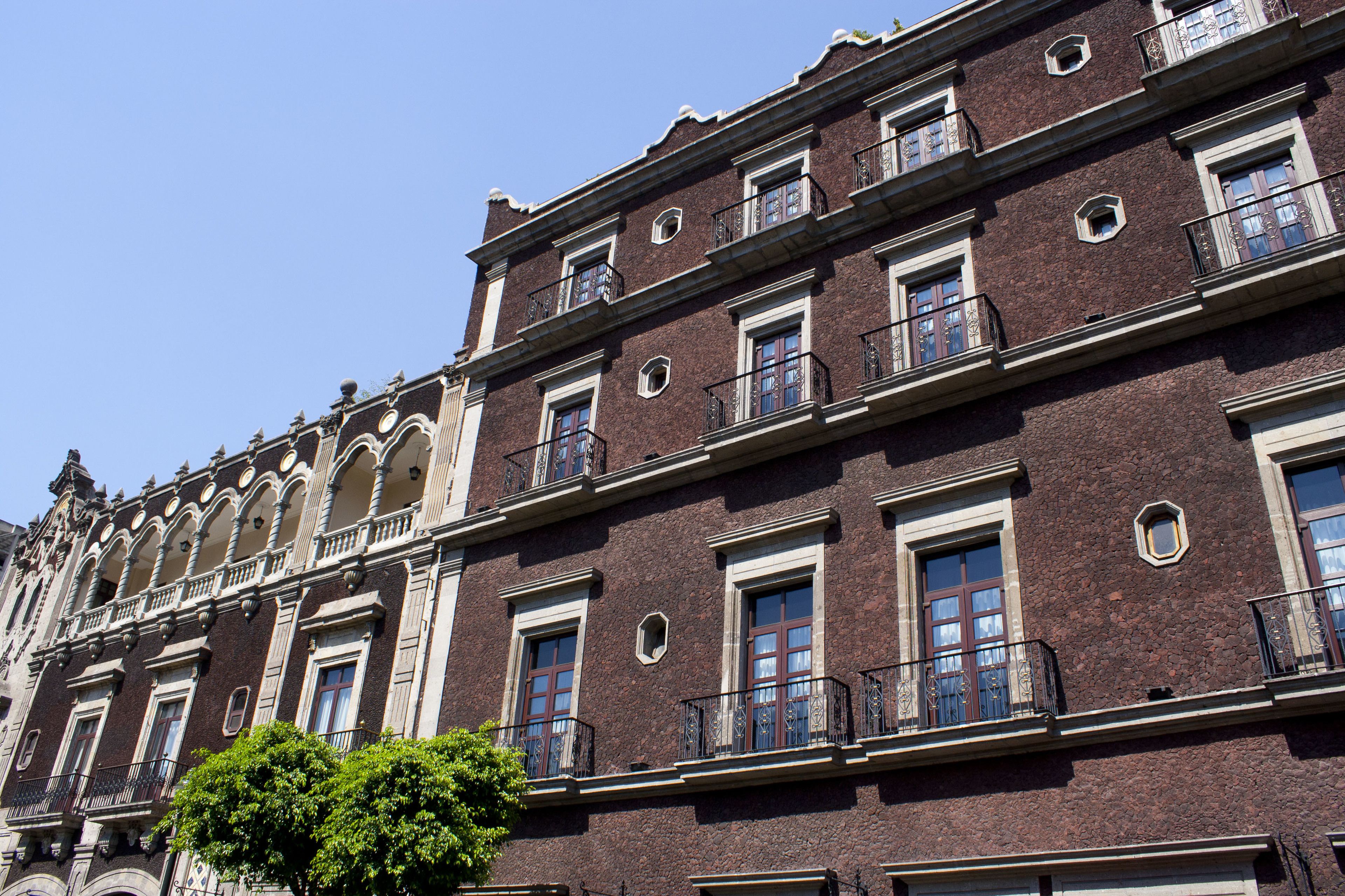 Un immeuble à plusieurs étages, de style architectural classique, caractérisé par des balcons richement décorés et de grandes fenêtres.