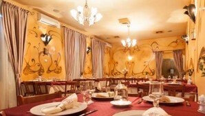 A dining area with tables set for four, each with red tablecloths, white plates, and silverware. - Deja Vu Pension (Cluj-Napoca)