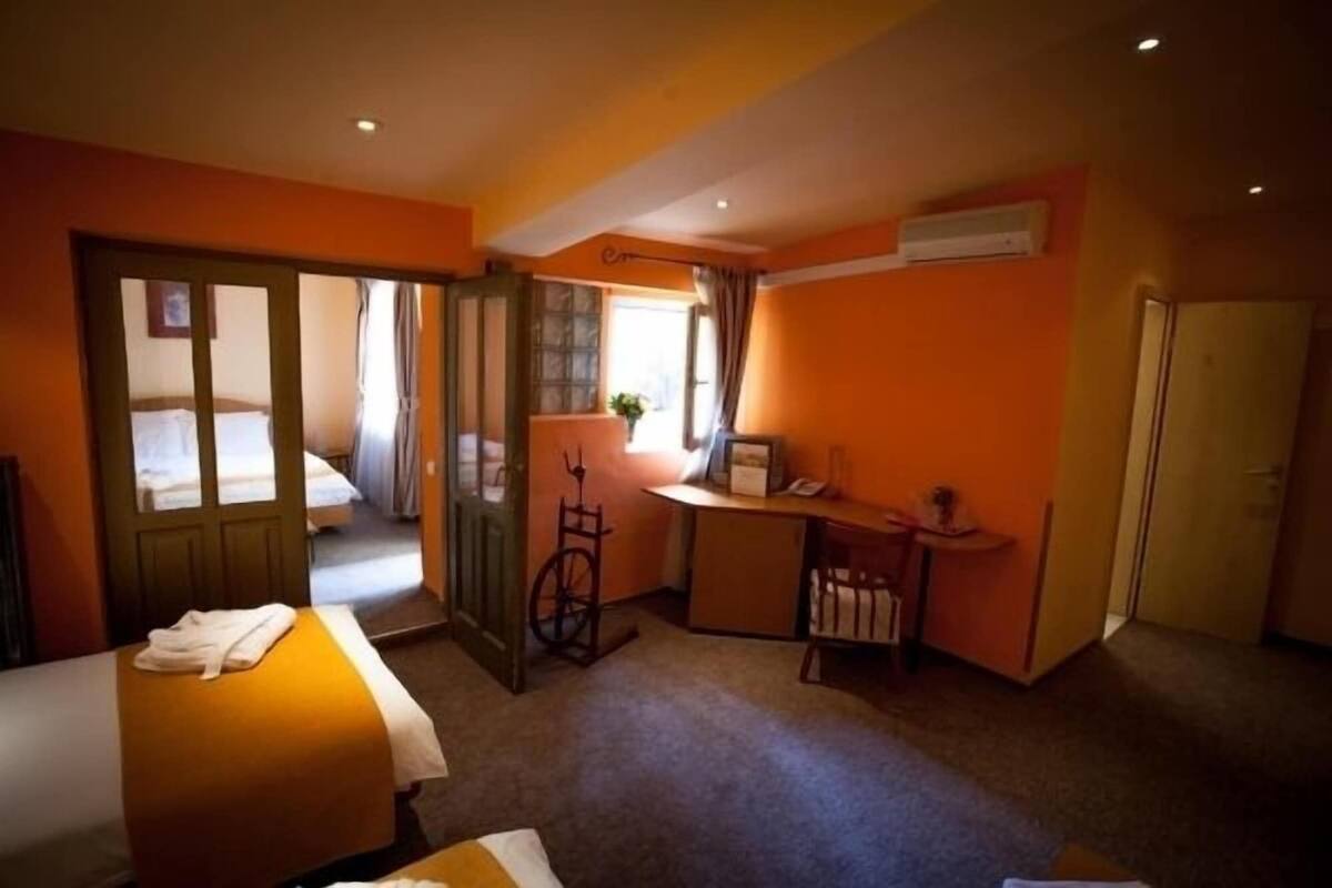 Una habitación de hotel compacta con una cama, un escritorio, una silla y un armario.