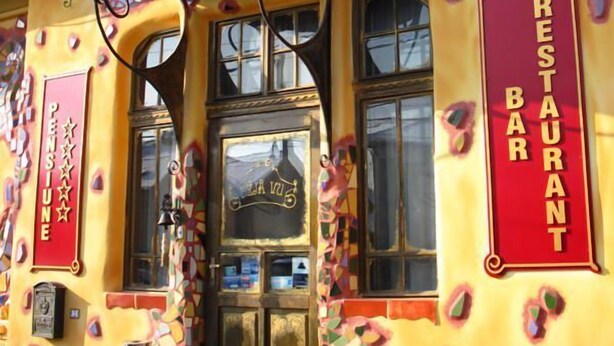 A colorful building with a mosaic pattern and a sign that reads "DEJA VU RESTAURANT". - Deja Vu Pension (Cluj-Napoca)