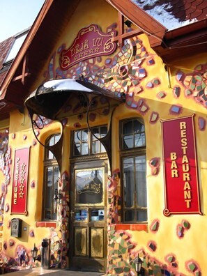 Een kleurrijk gebouw met een mozaïekpatroon en een bord waarop staat 'DEJA VU RESTAURANT'.