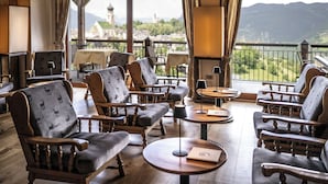 Cómoda sala de estar con mobiliario de madera y vistas a un paisaje montañoso.