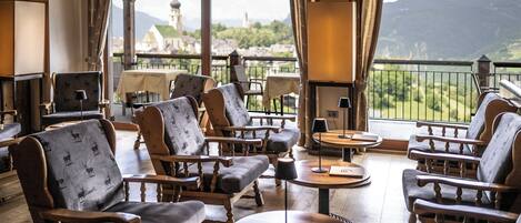 Cómoda sala de estar con mobiliario de madera y vistas a un paisaje montañoso.