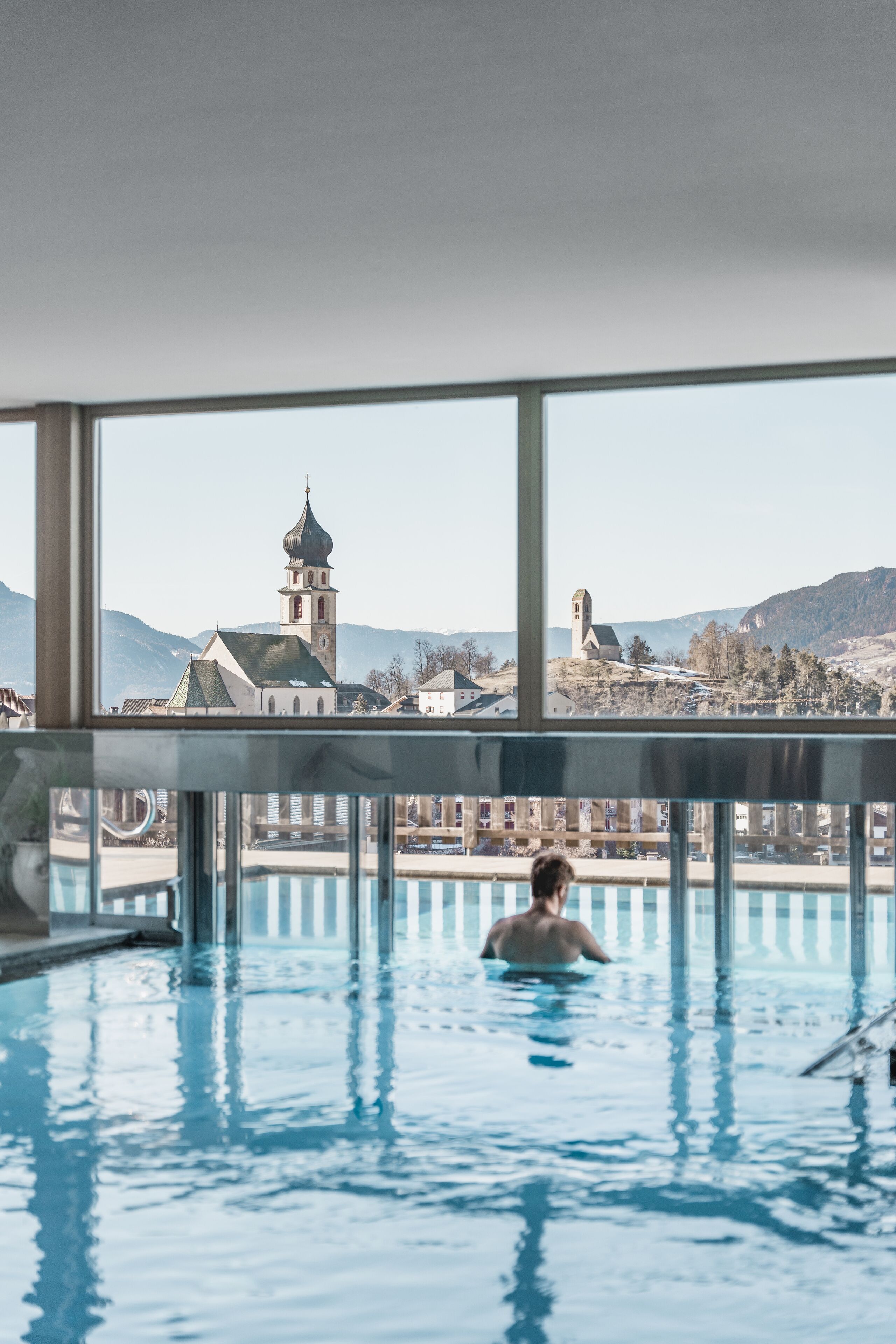 Piscina con vista a una iglesia y montañas.