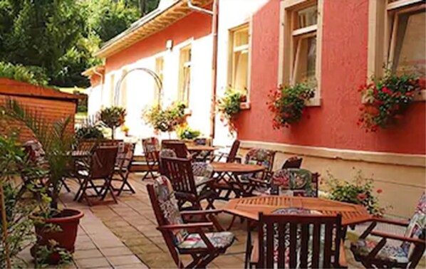 Un patio al aire libre con muebles de madera y plantas en macetas.