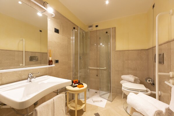 Un baño moderno con un lavamanos grande, cabina de ducha de vidrio y un inodoro.