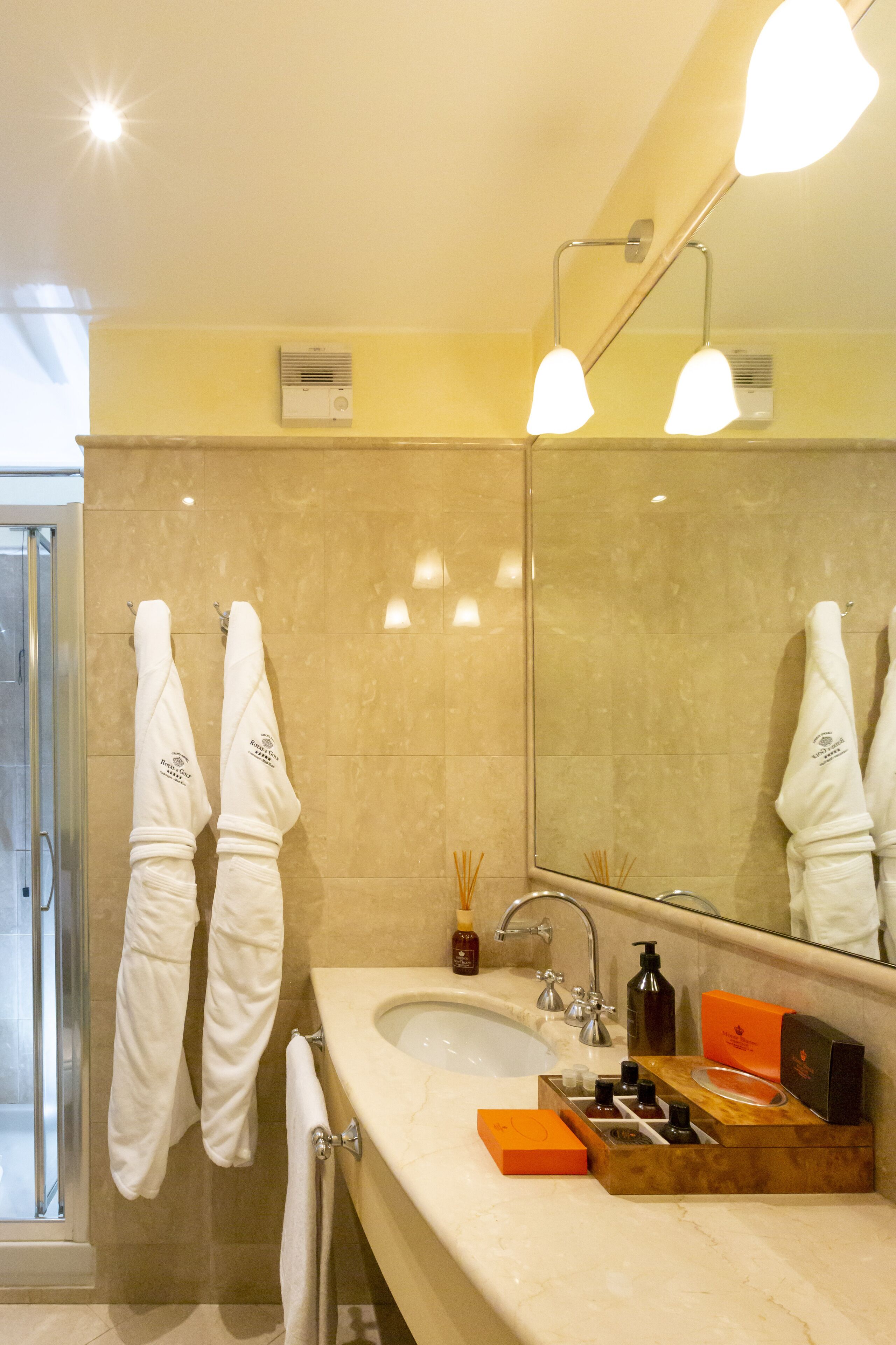 A bathroom with a sink, mirror, and two towels hanging on the wall.