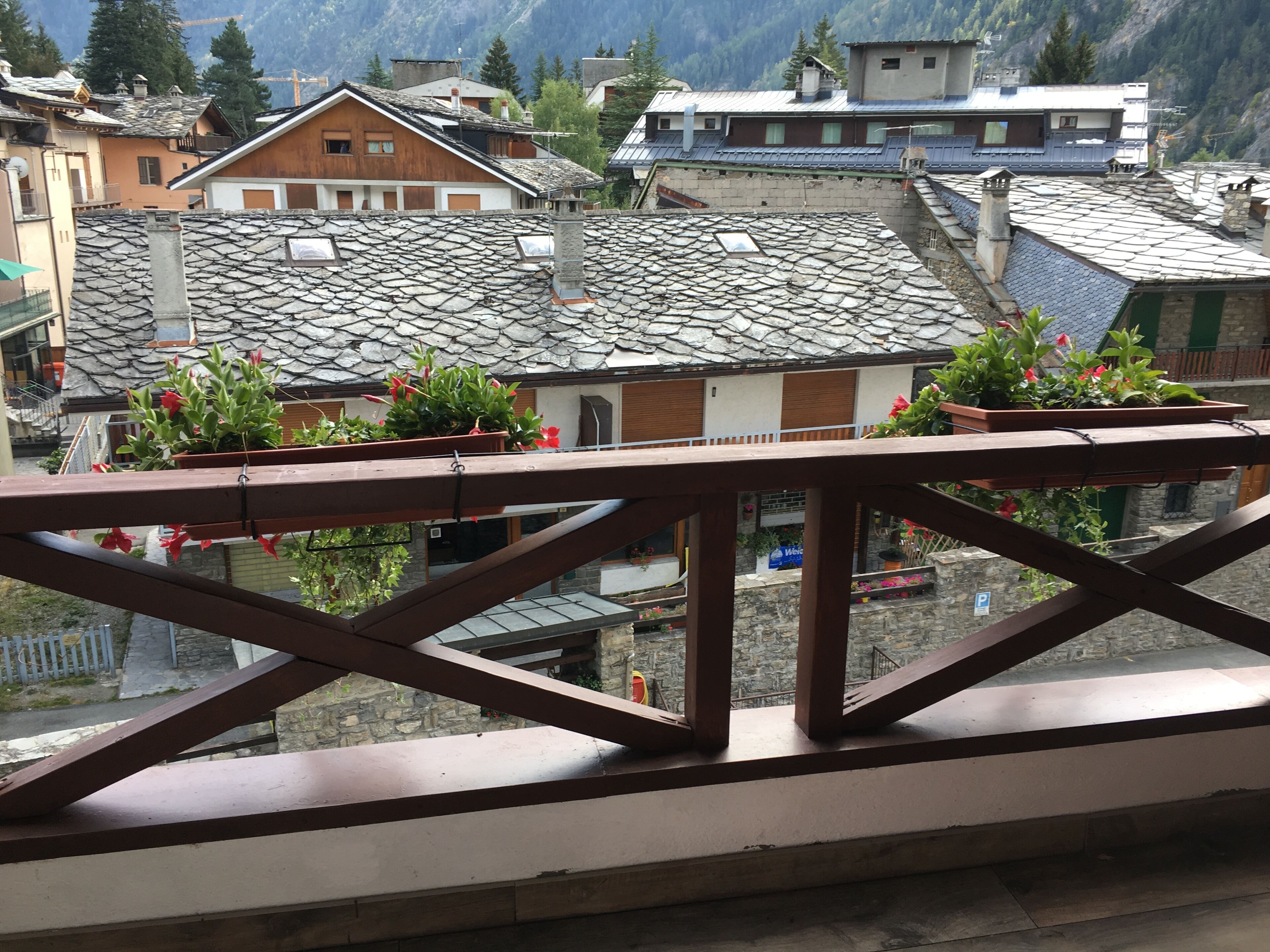 A balcony with a view of traditional buildings and mountains.