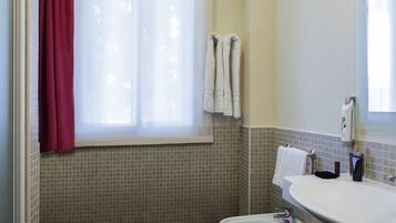 Ein Badezimmer mit Fenster, Waschbecken und Bidet.