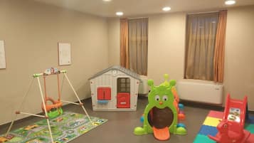 Children can play and explore in this spacious room featuring a playhouse, swing set, and play mat.