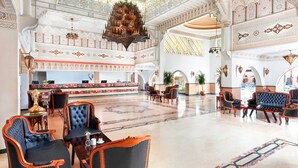 A spacious lobby with ornate chandeliers, a reception desk, and comfortable seating areas.